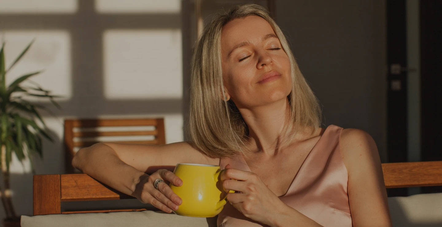 Woman enjoying morning coffee at home feeling confident after breast surgery – Ditesheim Cosmetic Surgery
